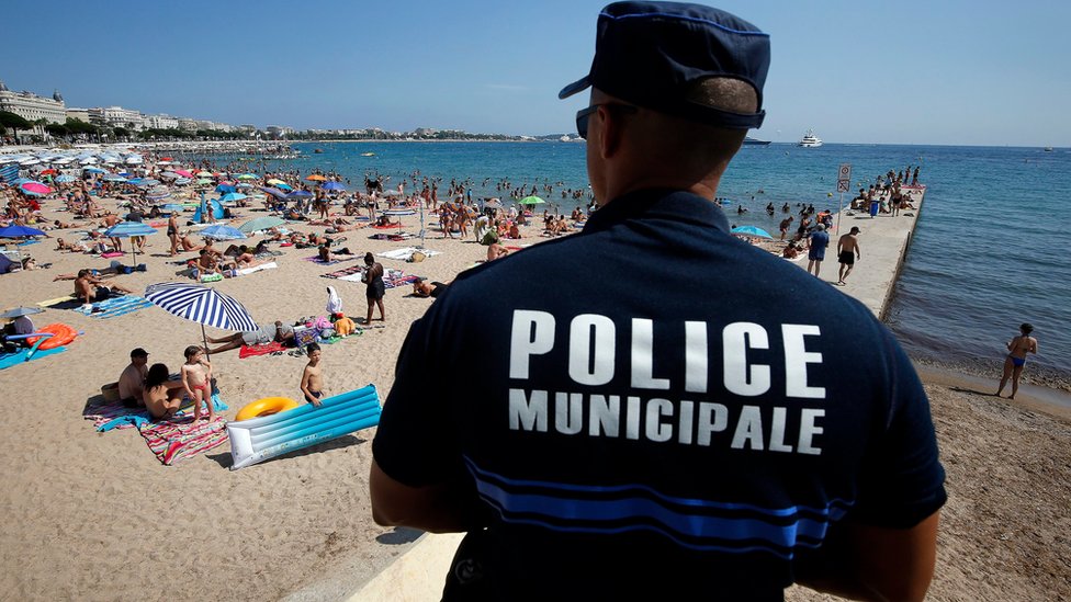 Французский полицейский патрулирует пляж в Каннах 4 августа 2016 г.