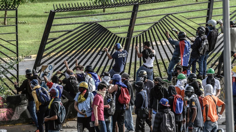 Decenas de manifestantes se encaramaron a la verja de la base aérea de La Carlota, lo que provocó la acción policial. Manifestantes tratan de entrar a la base aérea de La Carlota