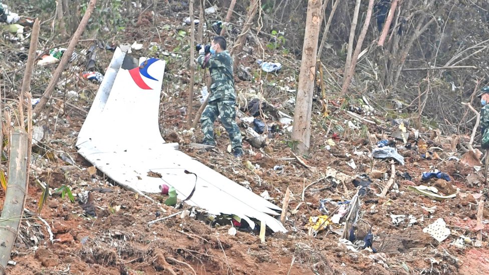 廣西梧州藤縣中國東航MU5735航班墜落事故墜落現場武警在一片機翼殘骸旁邊作業（新華社圖片22/3/2022）