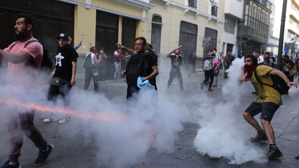 La policía ha estado usando gases lacrimógenos para dispersar las protestas contra el indulto. Manifestantes protestando contra el indulto en medio de gases lacrimógenos.