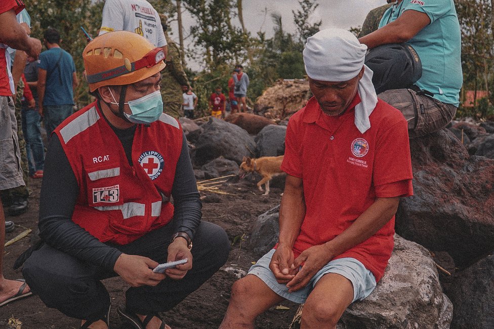Волонтер Красного Креста разговаривает с г-жой Сальвадор