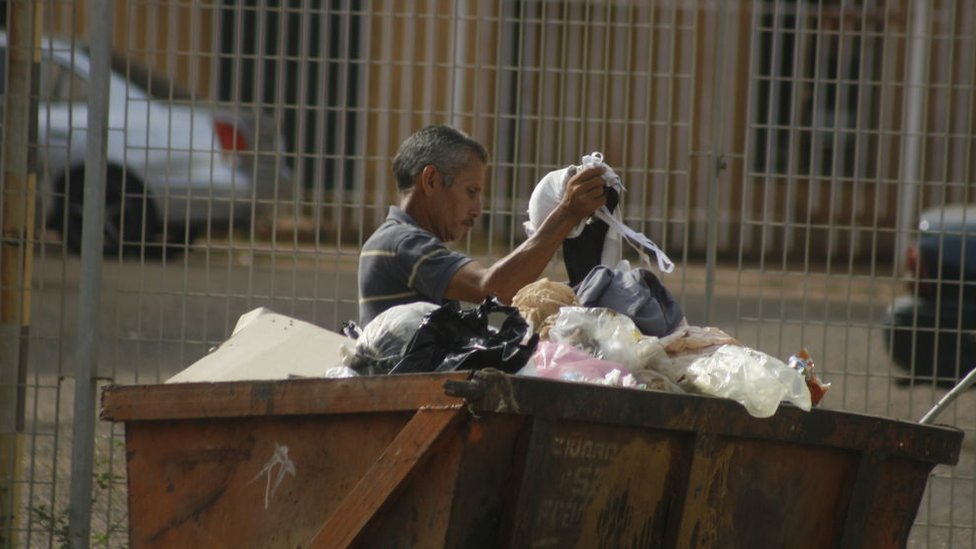 A man goes through the garbage to get food to eat in the municipality of San Francisco in Venezuela.