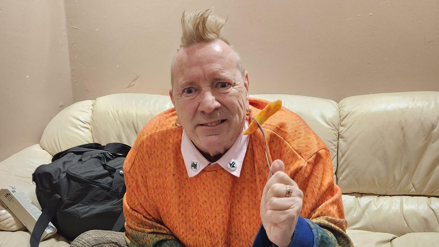 The Sex Pistols' John Lydon tries orange chips in Bilston