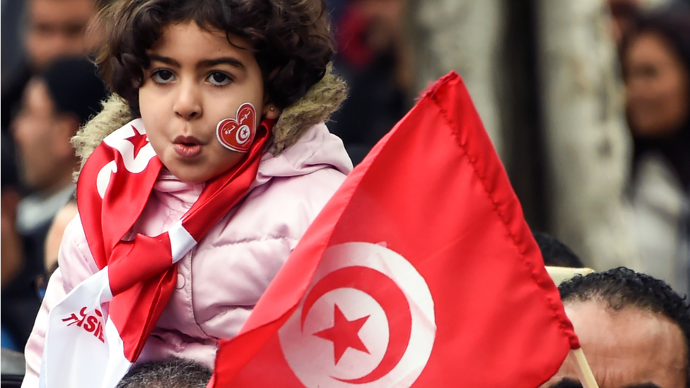 طفلة تتلفع بـ علم تونس