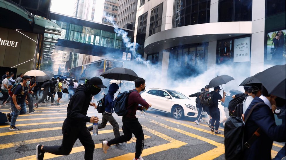 Протестующие бегут от слезоточивого газа в центре Гонконга