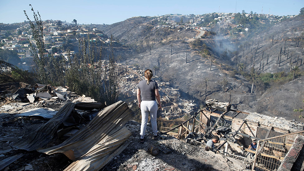 Una mujer mira la devastación tras el incendio en Viña del Mar.