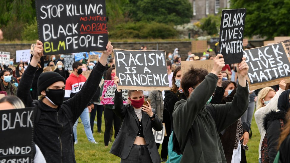 Pengunjuk rasa mengangkat plakat saat menghadiri unjuk rasa di Edinburgh pada 7 Juni.