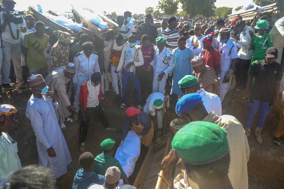 The governor of Borno state (CR in the background, with yellow hat and white and yellow robe) attended the victims' funerals on Sunday