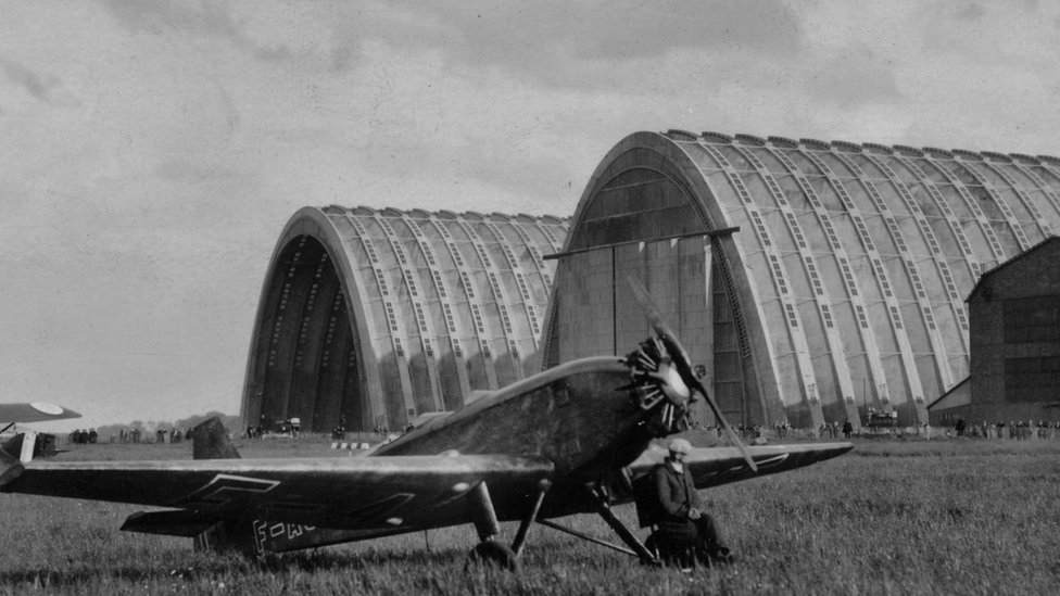 Se dice que el arquitecto brasileño Oscar Niemeyer encontró inspiración en el devoto poeta francés Claude Claudel: "Una iglesia es un hangar de Dios en la Tierra". Avión frente a hangares en 1925.