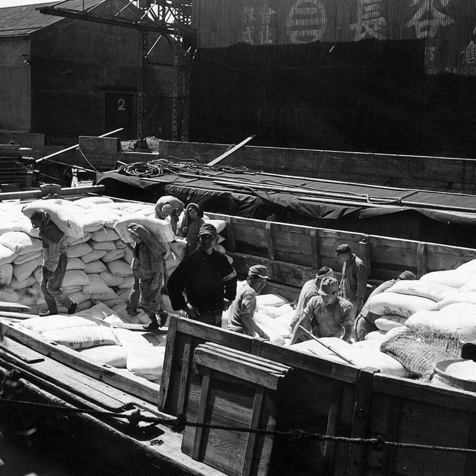 Estibadores descargan harina en un puerto de Japón en 1955.