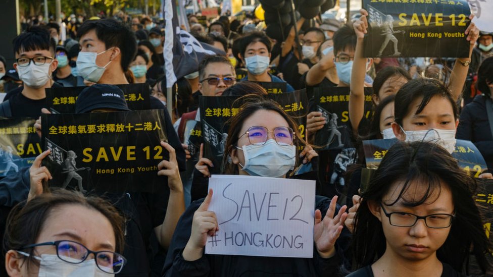 Taiwanese and local Hong Kong residents march in Taipei holding placards in support of the 12 Hong Kong democracy activists