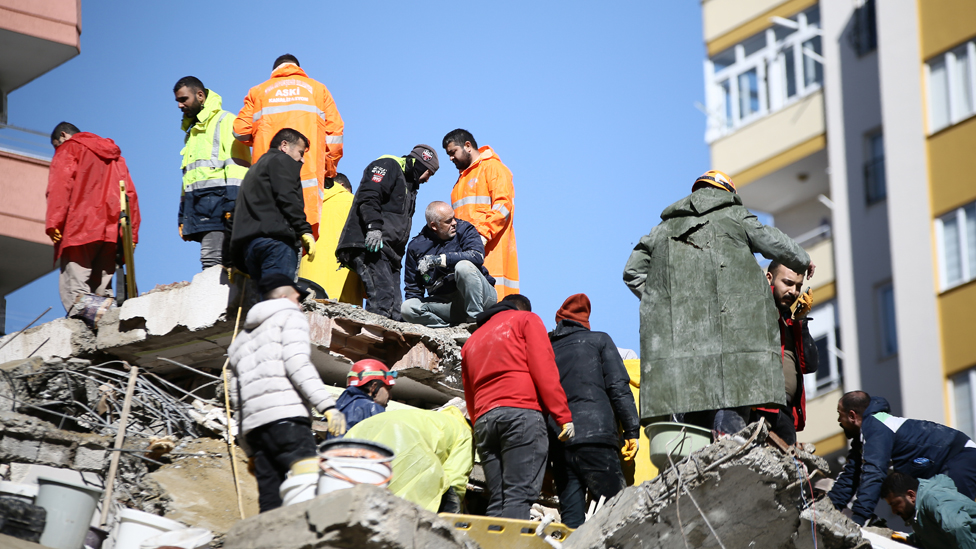 Rescuers work on a collapsed building in Adana, Turkey