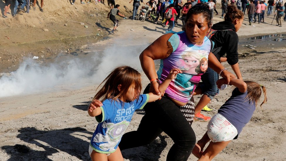 Una mujer huye de gases lacrimógenos junto a sus dos hijas en la frontera entre EE.UU. y México en noviembre de 2018