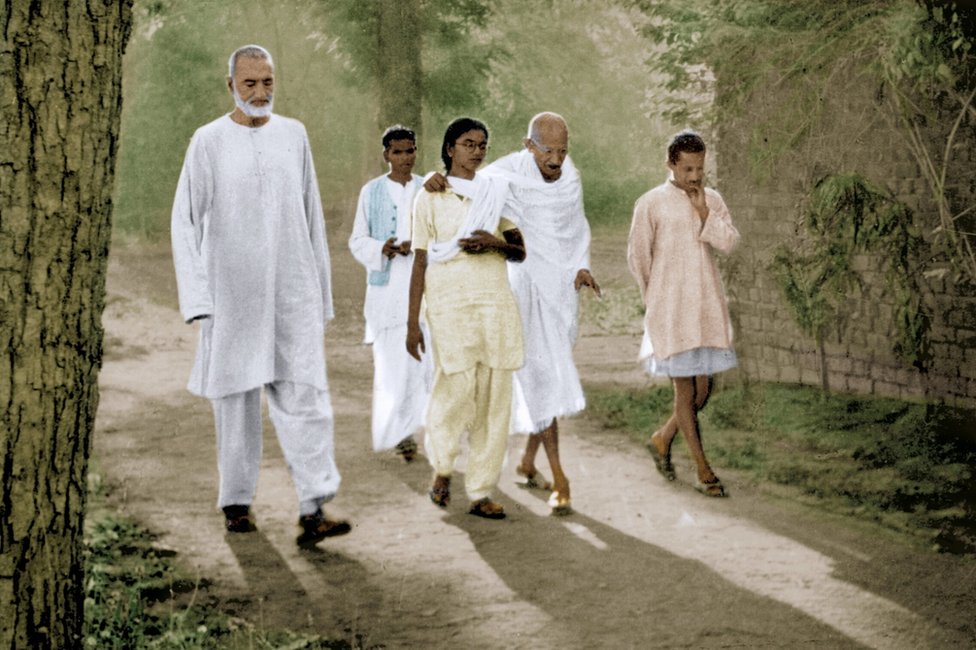 Mahatma Gandhi caminando con su sobrina nieta Mani Gandhi y otros compañeros, India, 1947