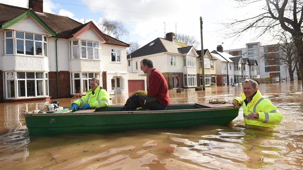 Жителя спасают из дома на лодке службы экстренной помощи во время наводнения в Херефорде.