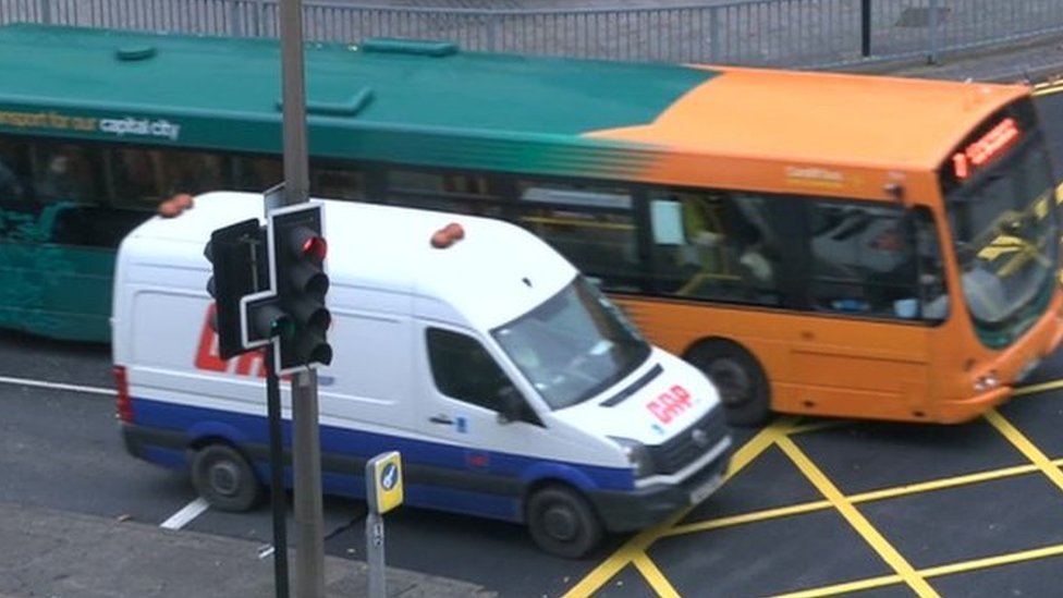Кардиффский автобус и микроавтобус на перекрестке желтых ящиков в центре города