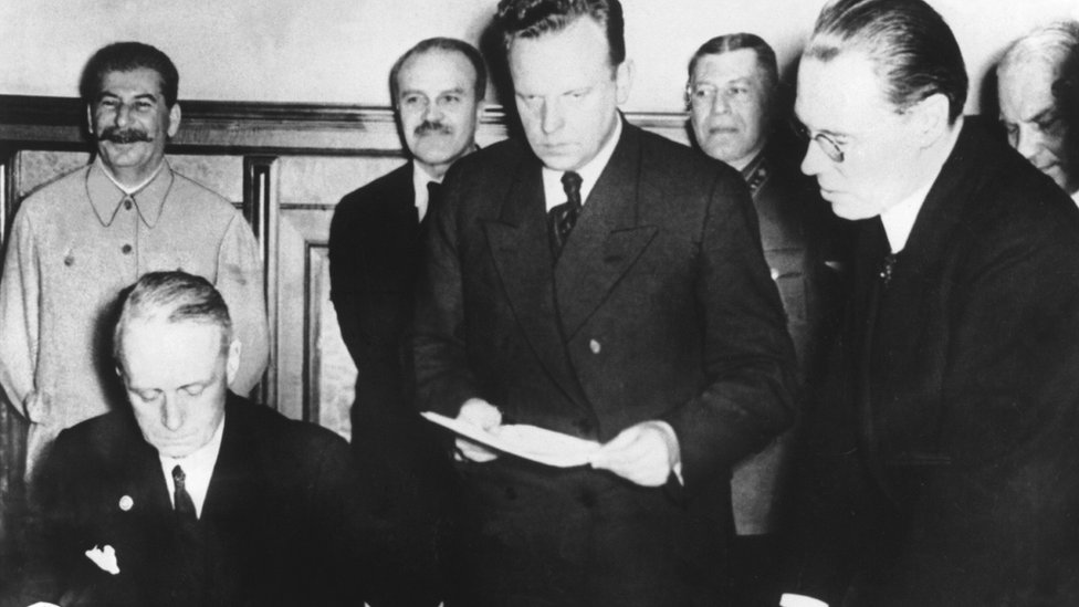 Joachim Von Ribbentropp, ministro alemán de Relaciones Exteriores, firmando el Pacto Germano-Soviético, acompañado de Stalin.