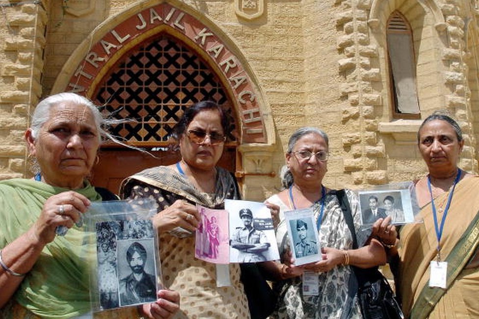Члены индийской делегации показывают фотографии пропавших без вести родственников военнопленных во время экскурсии по центральной тюрьме Карачи, 4 июня 2007 г.