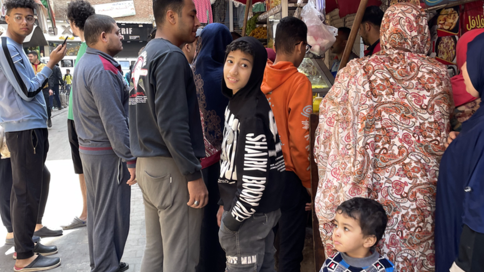 مجموعة من المواطنين يتجمعون أمام أحد المحال التجارية