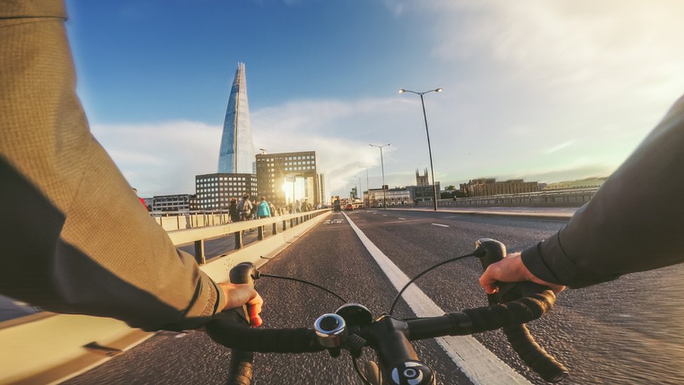 Someone cycling over a bridge in London