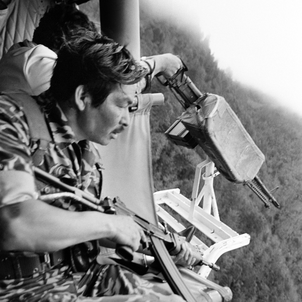 Soldados guatemaltecos se preparan para disparar contra los indios mayas desde un helicóptero Bell de fabricación estadounidense cerca de Santa Cruz del Quiché (1982)