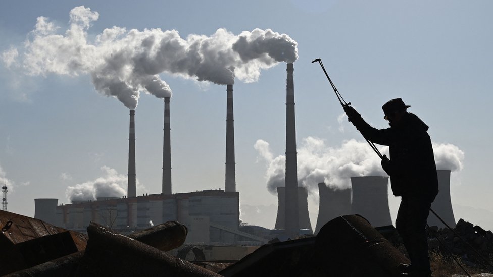 Um trabalhador usa uma tocha para cortar tubos de aço perto da central elétrica Datang International Zhangjiakou a carvão em Zhangjiakou China.