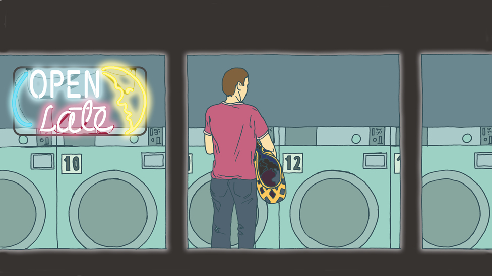 Hombre en una lavandería en la noche.