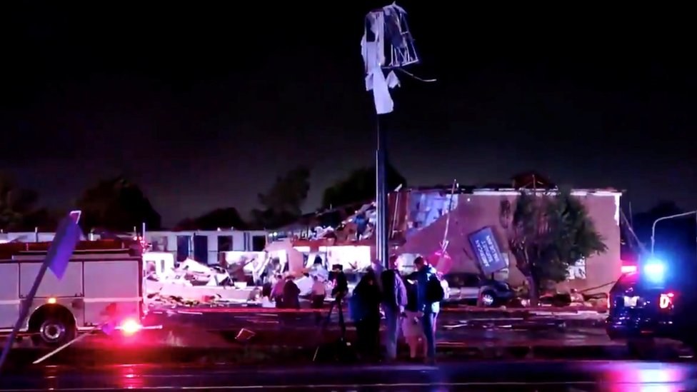 Машины скорой помощи видны возле частично разрушенного здания после того, как торнадо приземлился в Эль-Рино, штат Оклахома