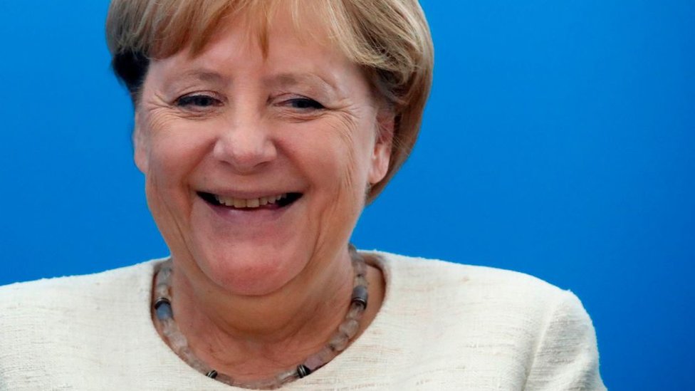 Merkel sonríe.