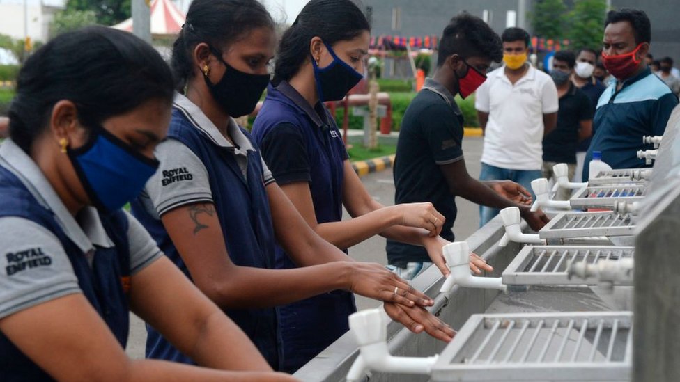 Workers washing their hands upon their arrival at the Royal Enfield motorcycle factory after the government eased a nationwide lockdown imposed as a preventive measure against the COVID-19 coronavirus, in Oragadam, Tami Nadu.