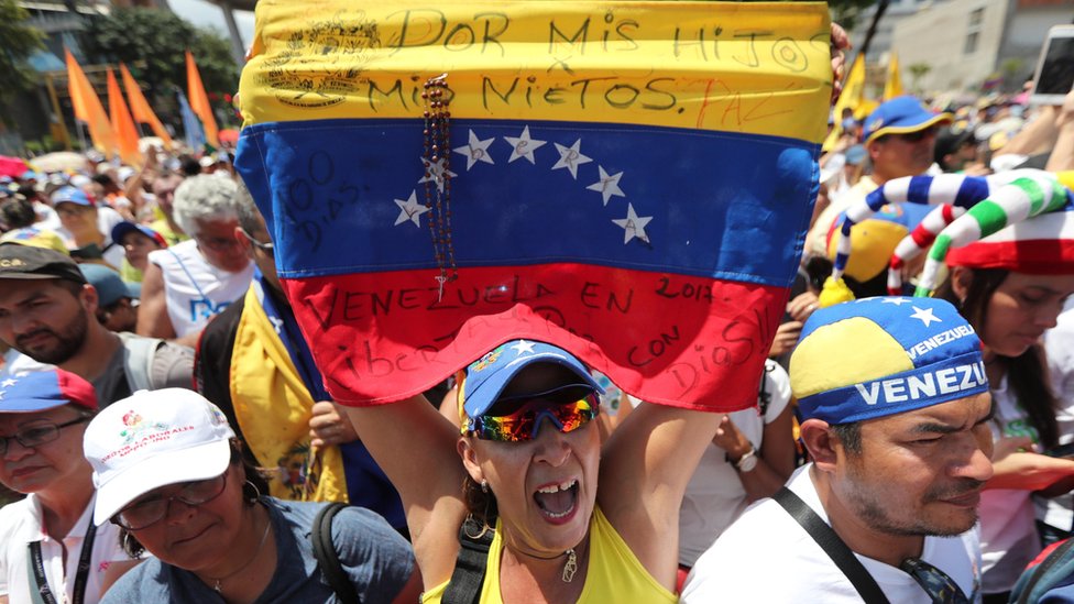 Mujer simpatizante de Guaidó con una bandera de Venezuela