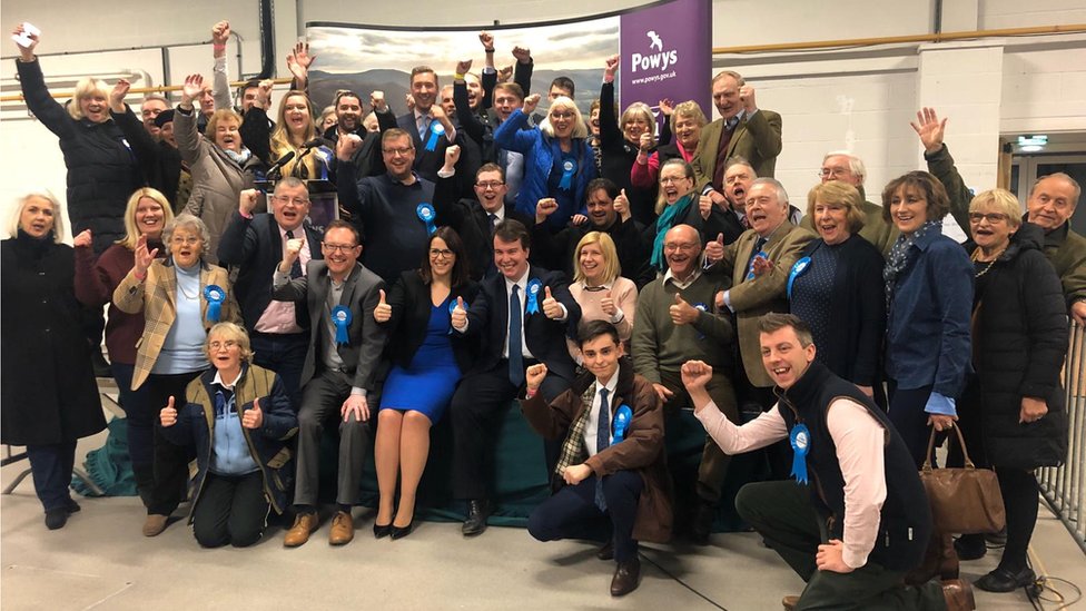 Все улыбаются, когда тори празднуют возвращение Брекона и Рэдноршира у либеральных демократов, всего через четыре месяца после того, как они проиграли его на дополнительных выборах