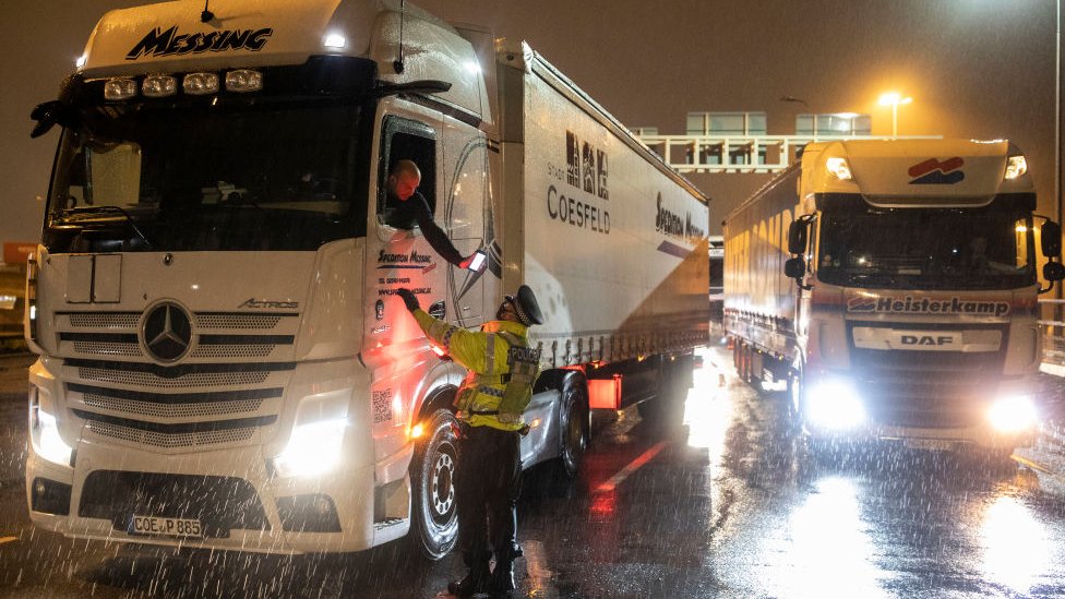 Полицейский проверяет телефон водителя грузовика в порту Дувра, Кент, во вторник вечером