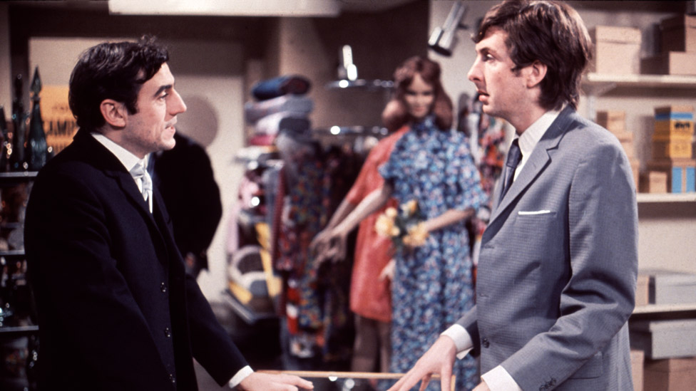 Джонс (слева) в роли менеджера магазина и Эрик Айдл в роли Криса Куинна в наброске Монти Пайтона «Универмаг-Покупка муравья»