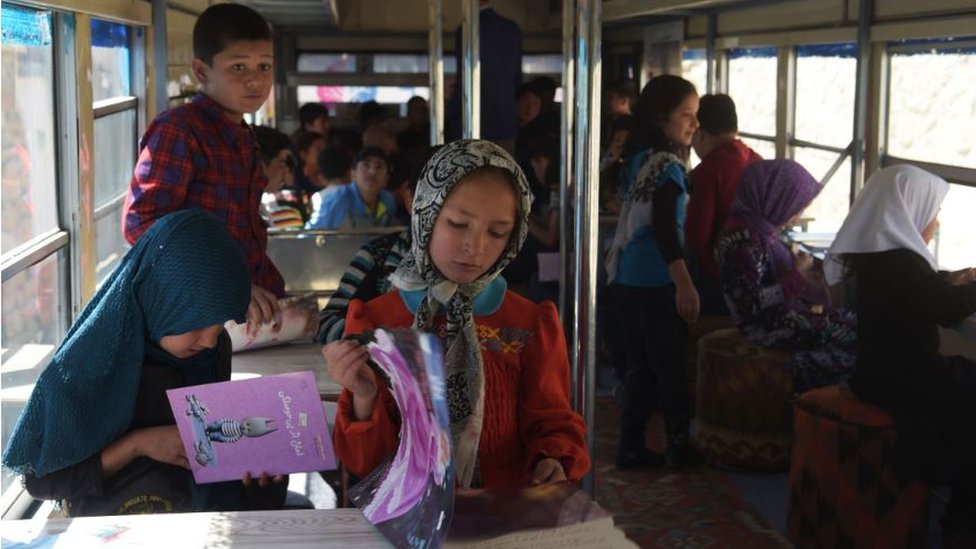 Afghan school children studying in a mobile library