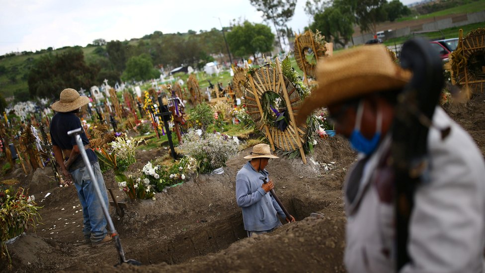 Рабочие кладбища роют новые могилы на кладбище Ксико на окраине Мехико