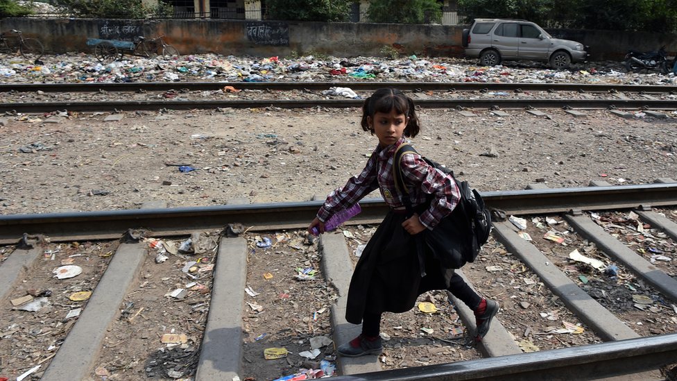 Индийская девушка идет по железнодорожным путям в Нью-Дели 13 октября 2015 г.