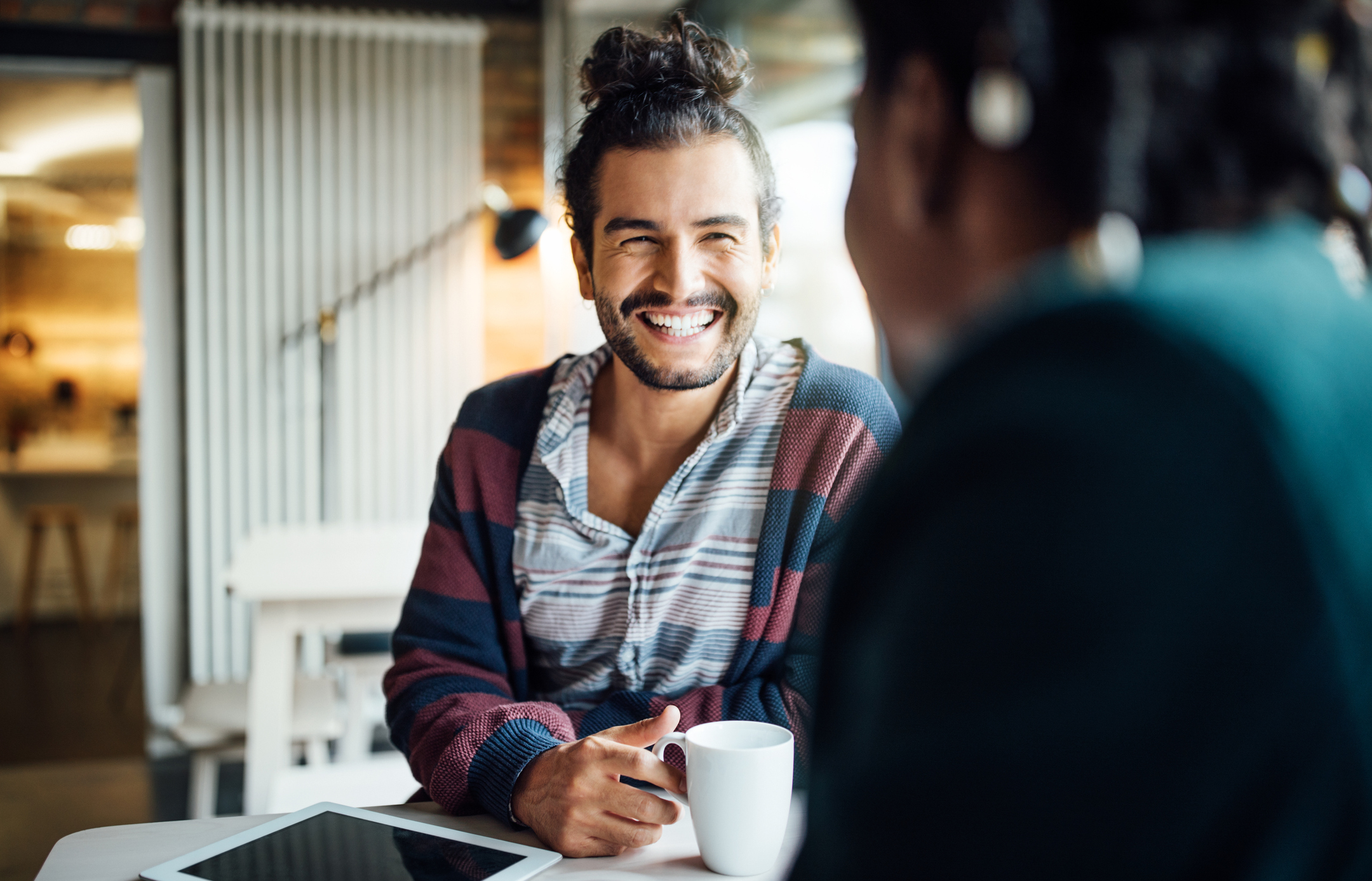 Homem tomando café com colega de escritório