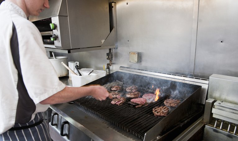 Un empleado de un restaurante de comida rápida en una cocina.