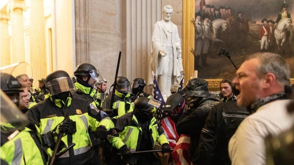Police face off against pro-Trump rioters beside Abraham Lincoln statue inside of the Capitol