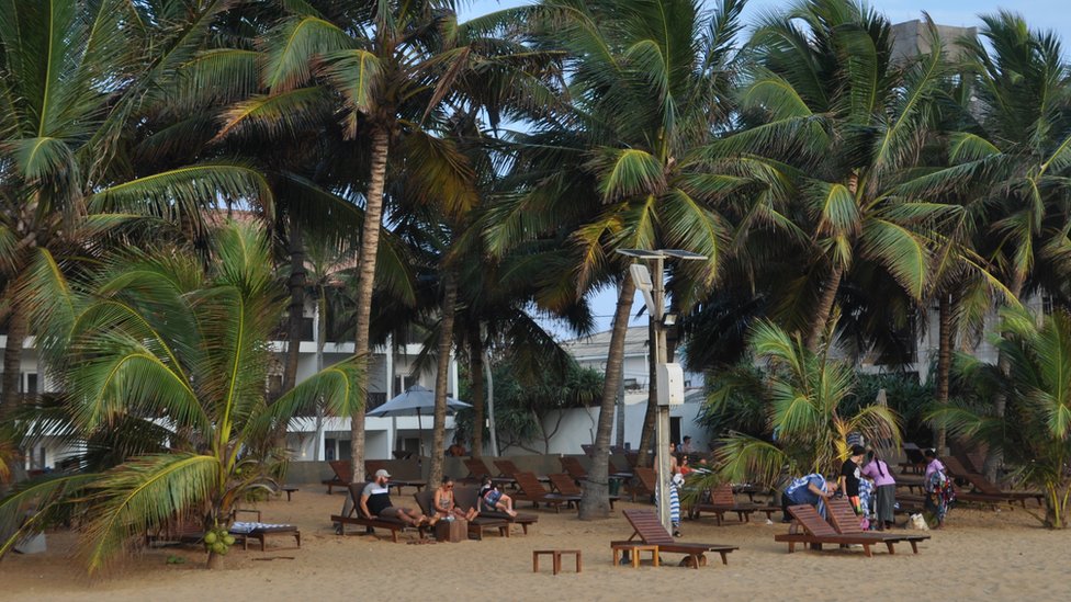 Туристы сидят на пляже в Шри-Ланке