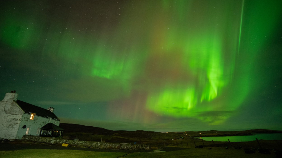 Aurora berwarna hijau cerah memenuhi seluruh langit di Kepulauan Shetland, Britania Raya.