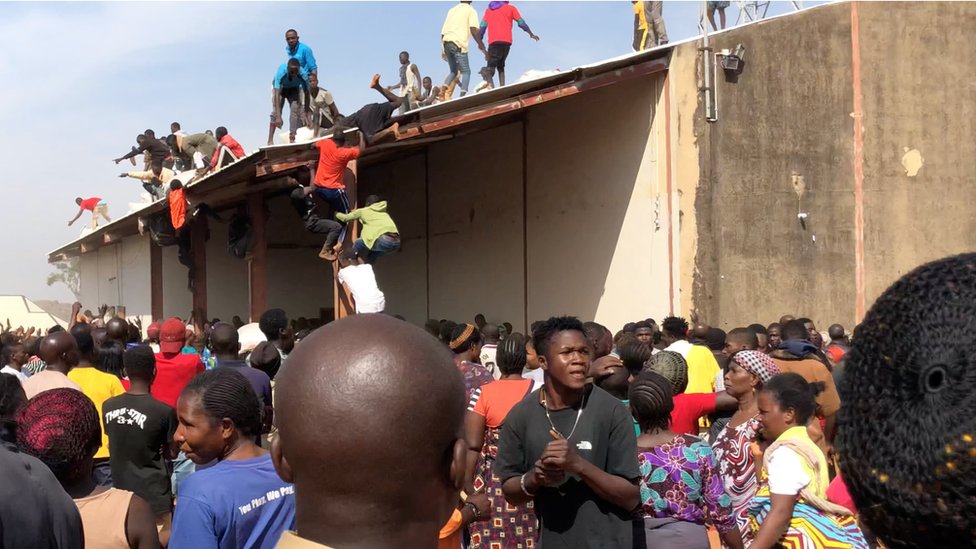 Люди собираются вокруг склада в Букуру, Нигерия, 24 октября 2020 г.