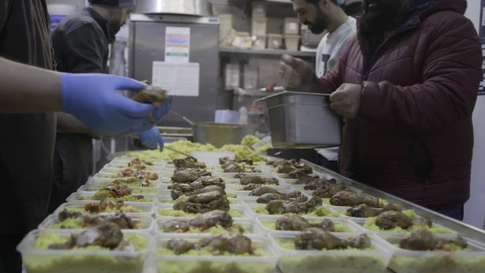 عمال في مطعم يعدون وجبات غذائية