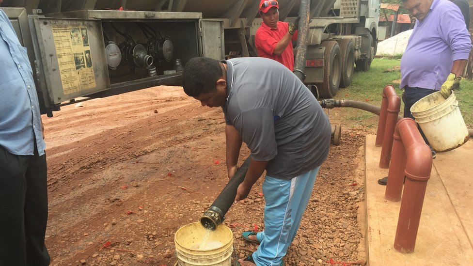 La gasolina se traslada en gandolas hasta las pocas estaciones de la zona en el sureste de Venezuela. Empleados vierten gasolina