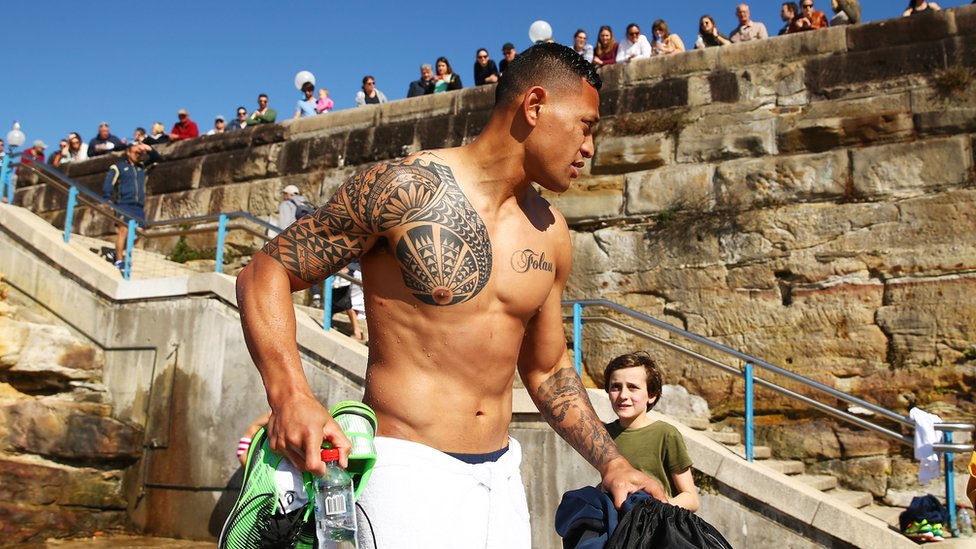Israel Folau sin camisa muestra sus tatuajes en Sídney, Australia. Agosto 9, de 2015