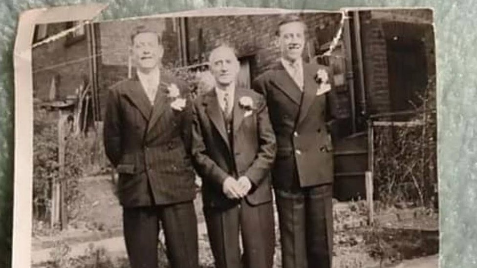 Черно-белое фото трех мужчин в свадебных костюмах