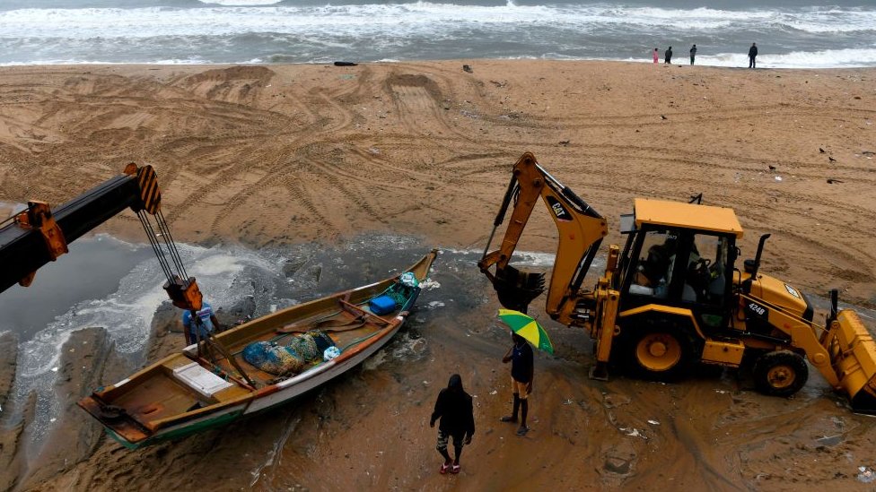 Рыбаки передвигают свои лодки, когда приближается циклон Нивар