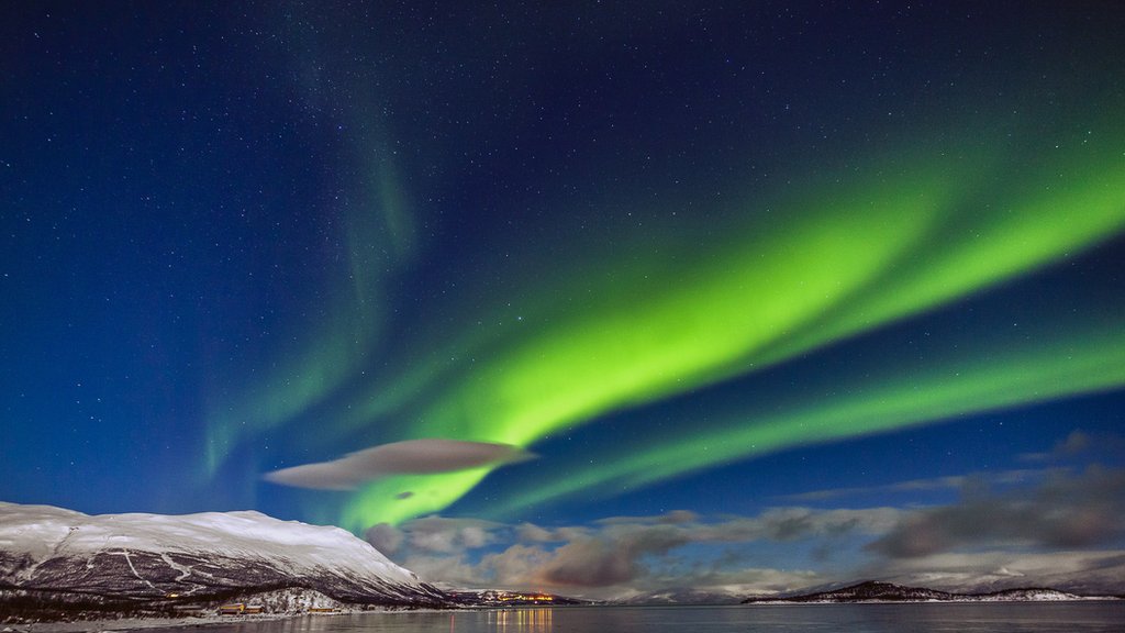 Impresionante aurora boreal aparece sobre el lago Tornetrask y el monte Nuolja en la Laponia sueca