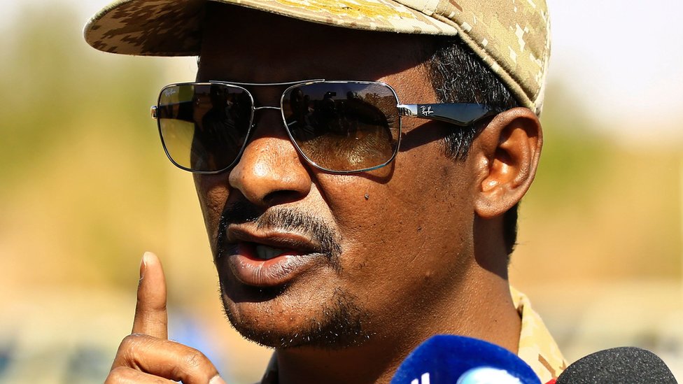 Хемети в солнцезащитных очках и кепке выступает перед прессой в 2017 году